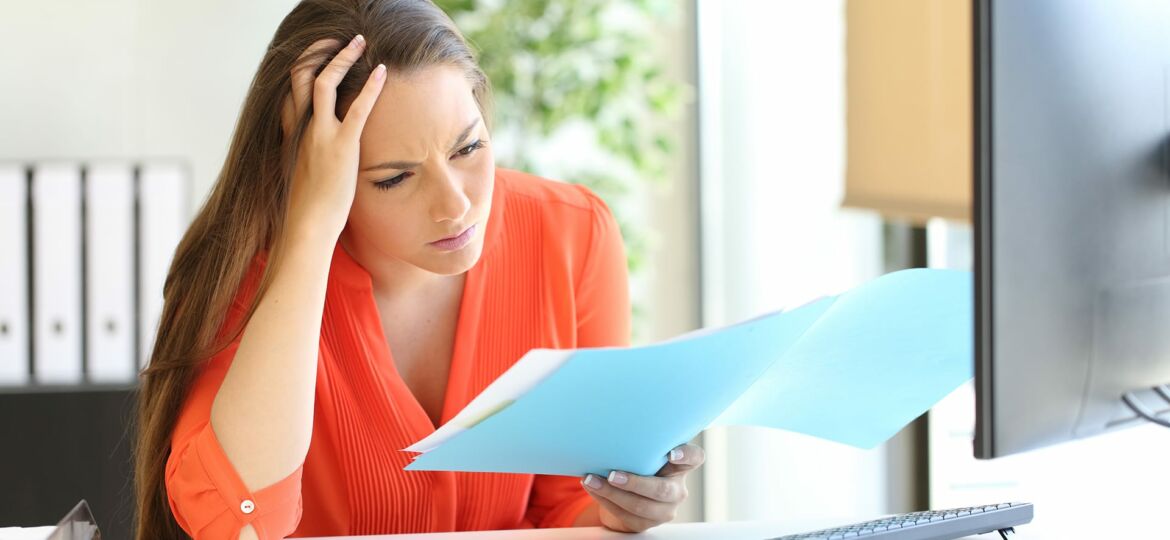Worried busnesswoman discovering mistake on document